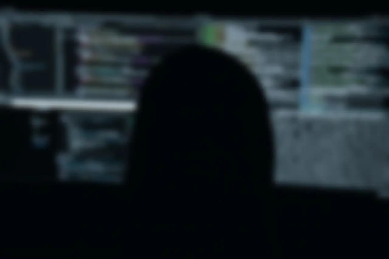 Pessoa diante de monitores com código e dados